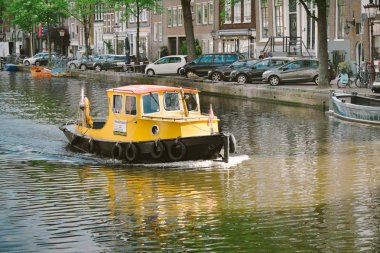 Amsterdam, Hollanda-Mayıs 13, 2019: güneşli bir günde bir Amsterdam kanalda sarı tekne yelken