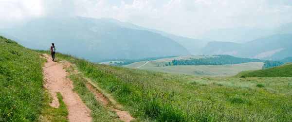 Mountain landscape and a person who is trekking on the path