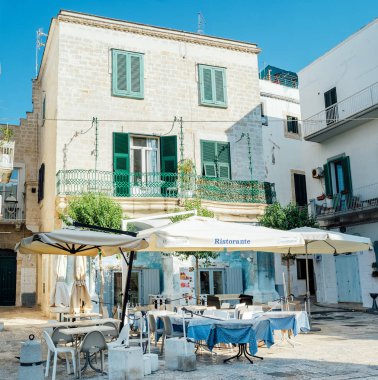 Ostuni, Puglia İtalya - 23 Ağustos 2019 Cuma: Tarihi merkezin sokaklarında bir açık hava restoranının masa ve sandalyeleri