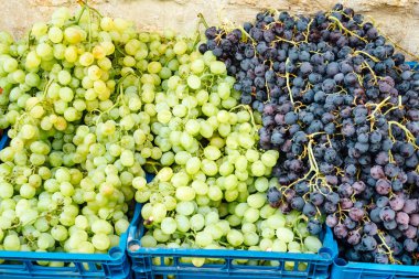 Bir açık pazarda kutularda beyaz ve siyah üzüm