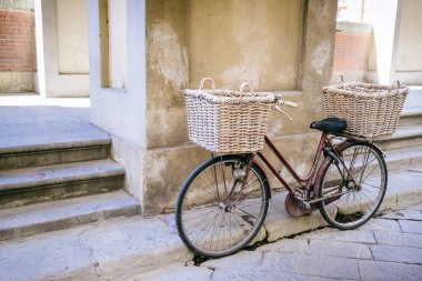 FLORENCE, İtalya - 25 Ağustos 2020: Floransa 'da sokak duvarına dayanan saman sepetli bisiklet