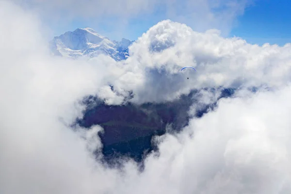 Parapente Entre Nuvens Baixas Com Montanhas Nevadas Como Fundo — Fotografia de Stock