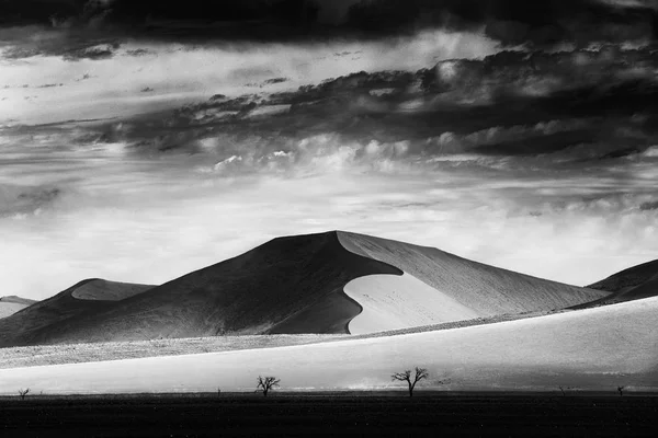 Black and white art Namibia, Big orange dune with blue sky and clouds, Sossusvlei, Namib desert, Namibia, Southern Africa. Red sand, biggest dun in the world. Travelling in Namibia.