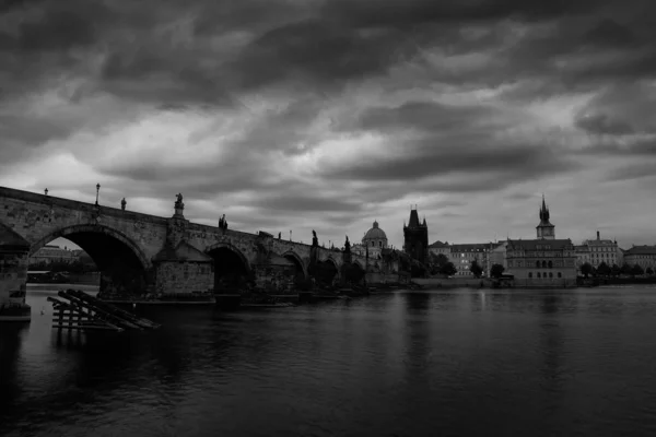 Prager Schwarz-Weiß-Foto. Die Karlsbrücke ist das Symbol der tschechischen Hauptstadt, die im Mittelalter erbaut wurde. nebliger Morgen mit Gewitterwolken. Reisen in der europäischen Stadt. — Stockfoto