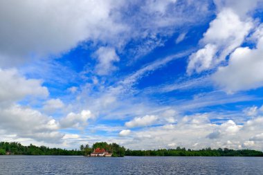 Kothduwa tapınağı ya da Koth Duwa Raja Maha Viharaya, Budist tapınağı, koyu mavi gökyüzü olan Madu Ganga bulutları. Bentota nehri, Sri Lanka. Yaz manzarası, kiliseli bir ada. Sudaki mangrov ağaçları.  