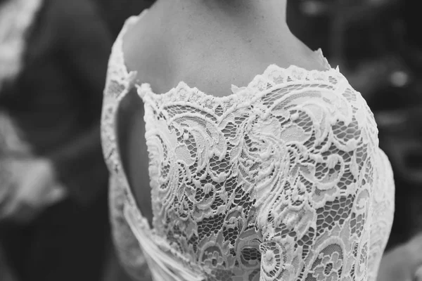 Primer plano de los hombros de una joven novia en un vestido de novia de encaje. Imagen en blanco y negro . — Foto de Stock