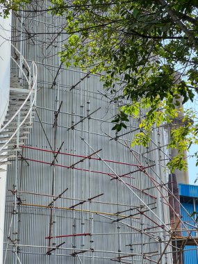 Şu anda yapım aşamasında olan büyük bir binada, işçilere ve malzemelere destek sağlayan kendi tarafında önemli bir yapı iskelesi bulunuyor.