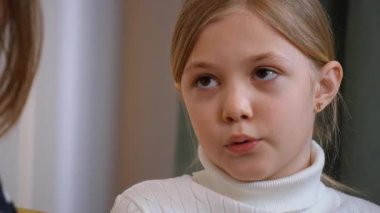 Sevgi dolu anne ve kız samimi bir anı paylaşıyor, sarı koltukta rahatça otururken derin bir sohbete dalıyor, gerçek duygularını ve aile dinamiği içinde anlayış gösteriyor.