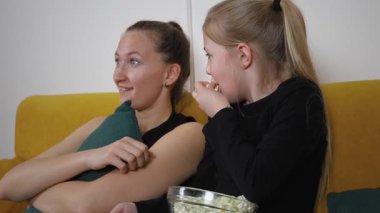 Korkutucu, film ve kızı kanepede oturan olgun bir anne. Televizyon şovu ya da oturma odasında patlamış mısır. Hafta sonu, annem kanepede kız arkadaşımla televizyon, korku ya da korku izliyoruz.