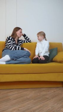Anne ve kızı sarı bir kanepeye oturup ciddi bir konuşma yapıyorlar. Muhtemelen hassas bir konu hakkında. Aile bağlantısı ve iletişim videosu hazırlıyorlar.
