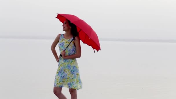 Elegancka Kobieta Sukience Spacerująca Plaża Czerwonym Parasolem Odbicie Morza Piękna — Wideo stockowe