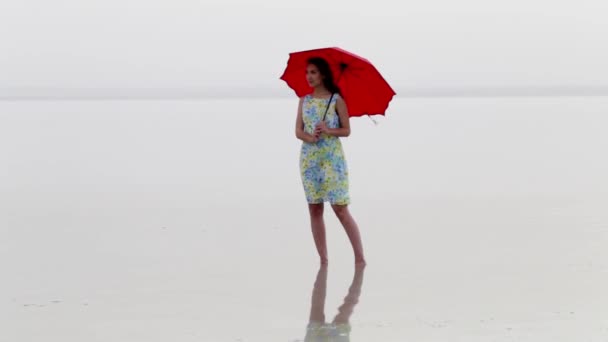 Elegante Mujer Vestido Playa Caminando Con Paraguas Rojo Reflejo Del — Vídeos de Stock