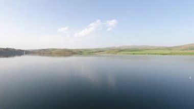 Yeşil çayır ve göl manzarası. Mavi gökyüzü ve doğa. Hava Aracı 4k 