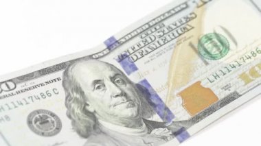 Düşen para, üzerine 100 dolar ve beyaz arka planda 50 dolar..