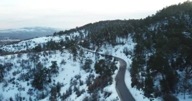 Kış mevsiminde güzel karlı dağda, kıvrımlı yolun hava aracı görüntüsü. 