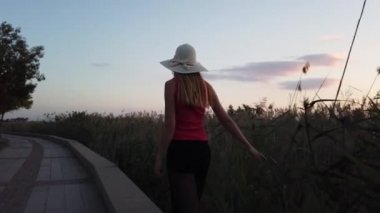 Şapkalı Kadın Güneşten Hoşlanıyor. Yaz güneşinin parıltısı ellerde. Hafta sonu sabah güneşleri. Tatil günü günbatımı.. 