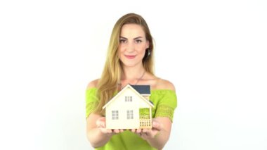 Elinde model ev, emlak sigortası ve bankacılık konsepti olan genç bir kadının elleri.  