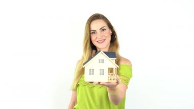 Elinde model ev, emlak sigortası ve bankacılık konsepti olan genç bir kadının elleri.  