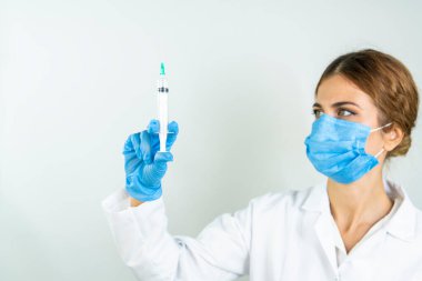 Sıvı aşılarla dolu bir şırıngayı laboratuvarda tutan doktor ya da bilim adamı olan Covid-19 Corona virüsüne karşı kavramsal mücadele: hastalıklar, tıbbi bakım, bilim.   