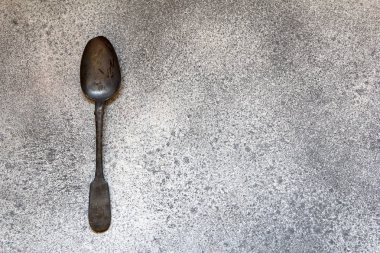 Gri beton tarzı antika gümüş kaşık. Vintage tarzı. Üstten görünüm.