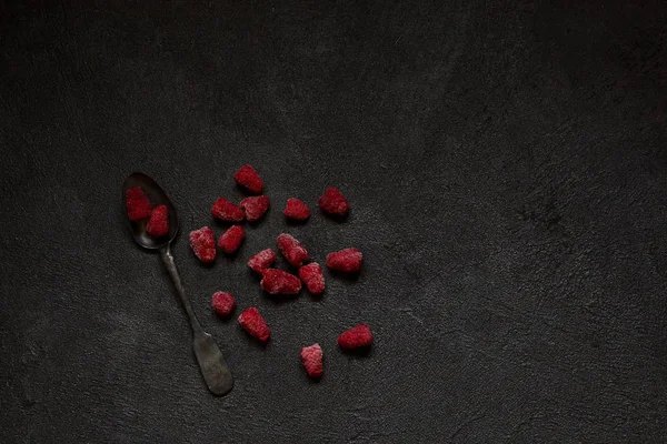 Ahududu üzerinde kopya alanı metin veya yazıt için siyah beton zemin üzerine Gümüş antika kaşık çilek donmuş. Sağlıklı gıda fikir. Üstten görünüm.