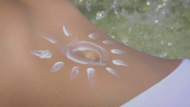 Bir kız, güneş koruma kremi bir güzel tabaklanmış vücudunda güneşli bir yaz aylarında boyalı Sunny, mavi deniz arka plan sürülür. Kavram deniz dinlenme, Güneş, seyahat, tatil, zevk, sıcak, ısı.