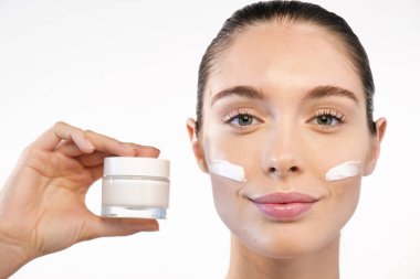 nemlendirici krem şişe krem yüz tutan kadın 
