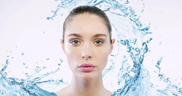 beautiful caucasian woman with perfect face skin looking at camera, water splashes on background