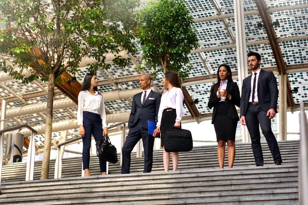 瞬間にスーツとネクタイを着てさまざまな民族グループからのビジネス人をリラックス 金融市場と世界経済のパフォーマンスについてお話しします 国際的なチーム — ストック写真