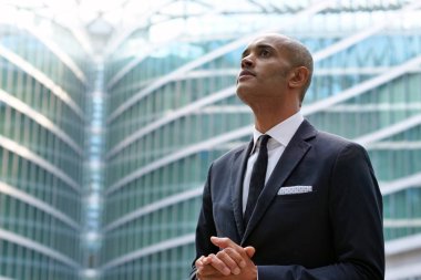 Bir takım elbise ve kravat, mutlu ve gülümseyerek kameraya ve arka planda çok etnik gruptan oluşan iş adamları bir grup göründüğü bir işadamı portresi. Kavramı: başarı ve kariyer