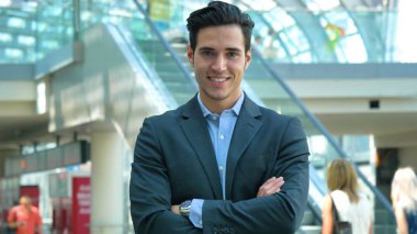 Ararken, bir inşaat arka planda gülümseyen genç bir yakışıklı işadamı takım, istasyonda portresi. Konsept: yeni iş, iş ilişkileri, kariyer büyüme, başarı.