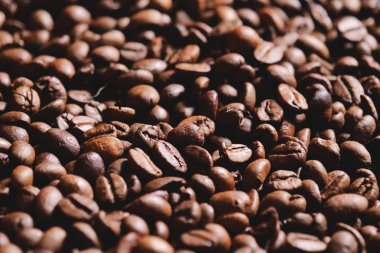 Ahşap arka plan üzerinde üstten görünüm bir kahve doku. Taze kaliteli kahve çekirdekleri hala sıcak ve dumanı tüten. Kavramı: gevşeme, aroma ve parfüm, Brezilya ve İtalyanca