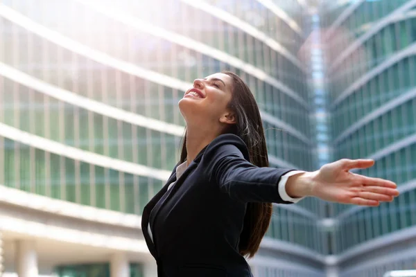 スーツを着たビジネスウーマン空に彼女の腕を上げるし 自由と彼女の仕事での成功の記号として呼吸 — ストック写真