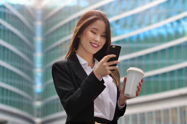 スーツとネクタイ 幸せとオフィスの外 携帯電話を使用してメッセージとコントロールの電子メールを送信しながら笑顔での東洋ビジネス女性の肖像 ネットワーク — ストック写真