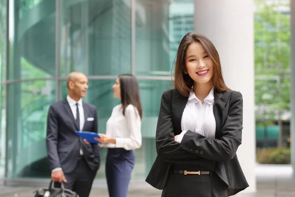 Portrait of a business woman, in a suit and tie, happy and smiling as she looks at the camera and crosses her arms, proud of her work. Concept of: success, finance and female career