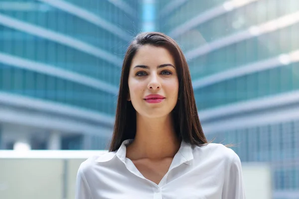 Portrait of a business woman, in a suit and tie, happy and smiling as she looks at the camera and crosses her arms, proud of her work. Concept of: success, finance and female career