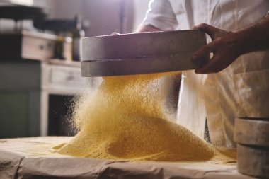 Bir çiftçinin bir el Sarı un kalitesi ve hammadde özünü hissetmek, bir avuç alır. Kavramı: gelenek, tarım, un, doğa sevgisi.