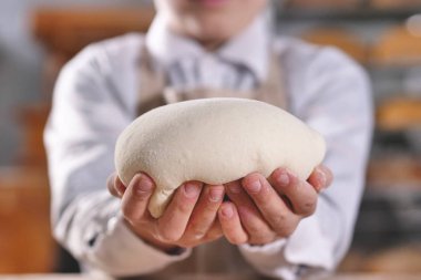 Bir fırıncı, yakın fırına ekmek hazırlamak için küçük yardımcısı elleriyle yoğurma. Kavramı: esnaf, baker, ham maddeler, gıda ve gelenekler için aşk