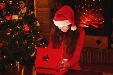 Noel günlerde güzel bir kadın ona hediye Noel ağacının altında açılır ve o hediyeyi açan o sihir gibi yanar. Kavramı: magic, Noel, Hediyelik, tatil.