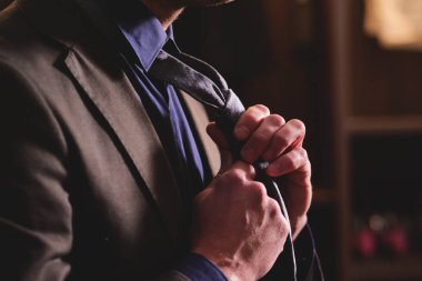 Terzi dükkanında terzi kıyafeti giyen bir adam takım elbise dener, kravatı düğümlenir ve onu çalışır halde tutar. Terzi, işadamı, zarafet kavramı.