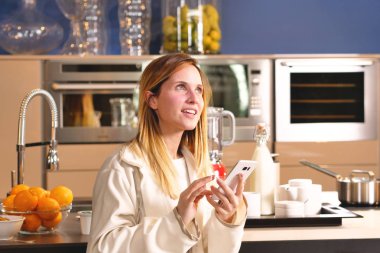 Evde bir kadın telefon kullanarak online ve kredi kartı bilgilerinizi girerek alışveriş. Kadın onun online alışveriş ile mutludur. Kavramı: alışveriş, nakliye, app ve teknoloji