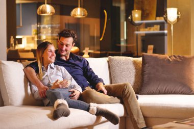 Aşık bir çift yeni evinde kanepede kucakladı televizyon seyretmek ve birlikte bir film izlemek. Kavramı: eğlence, sakin ol, tv.