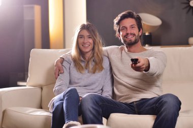 Aşık bir çift yeni evinde kanepede kucakladı televizyon seyretmek ve birlikte bir film izlemek. Kavramı: eğlence, sakin ol, tv.