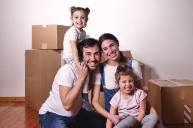 Güzel bir mutlu ve gülümseyen aile portresi birlikte yeni bir yolculuğa başlamak için yeni eve geldi. Kavramı: aşk, Aile, ev.
