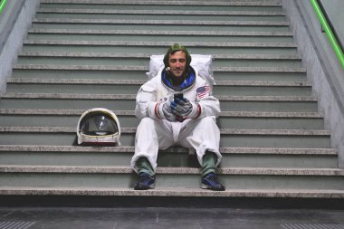 Bir astronot giymiş adam akıllı telefon çağrı ve mesaj göndermek için kullanır. Elinde telefon bakarak süre astronot gülümsüyor. Kavramı: telefon promosyonlar, iletileri ve uzaysal aramalar.