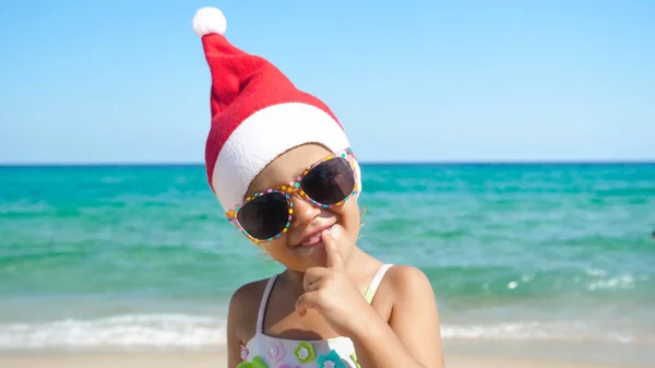 Маленькая Девочка Веселится Играет Море Шляпе Санта Клауса Купальнике Солнечных — стоковое фото