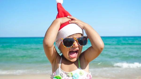 Uma Menina Está Divertindo Brincando Mar Chapéu Papai Noel Maiô — Fotografia de Stock
