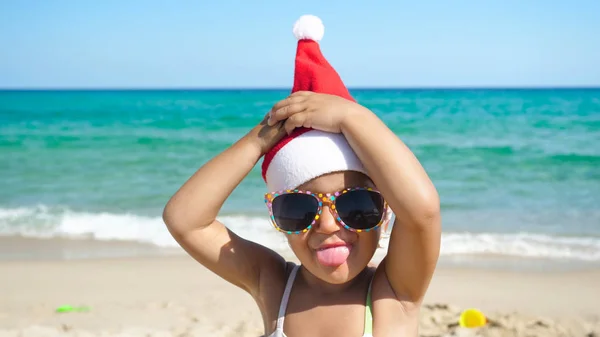 Uma Menina Está Divertindo Brincando Mar Chapéu Papai Noel Maiô — Fotografia de Stock