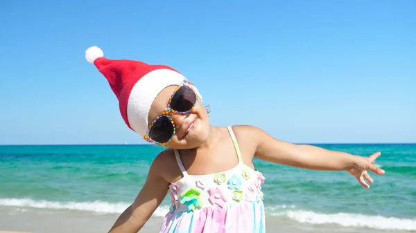 Uma Menina Está Divertindo Brincando Mar Chapéu Papai Noel Maiô — Fotografia de Stock