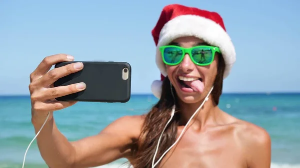 Piękna Dziewczyna Robienia Selfie Telefonu Morzu Kapeluszu Santa Claus Noszenie — Zdjęcie stockowe